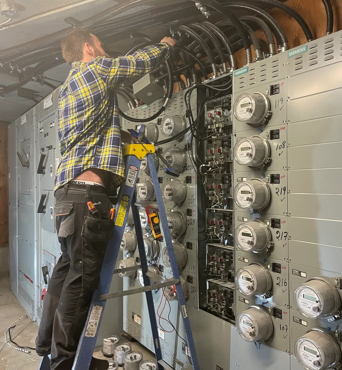 PTX electrician working on multi-unit electrical distribution equipment