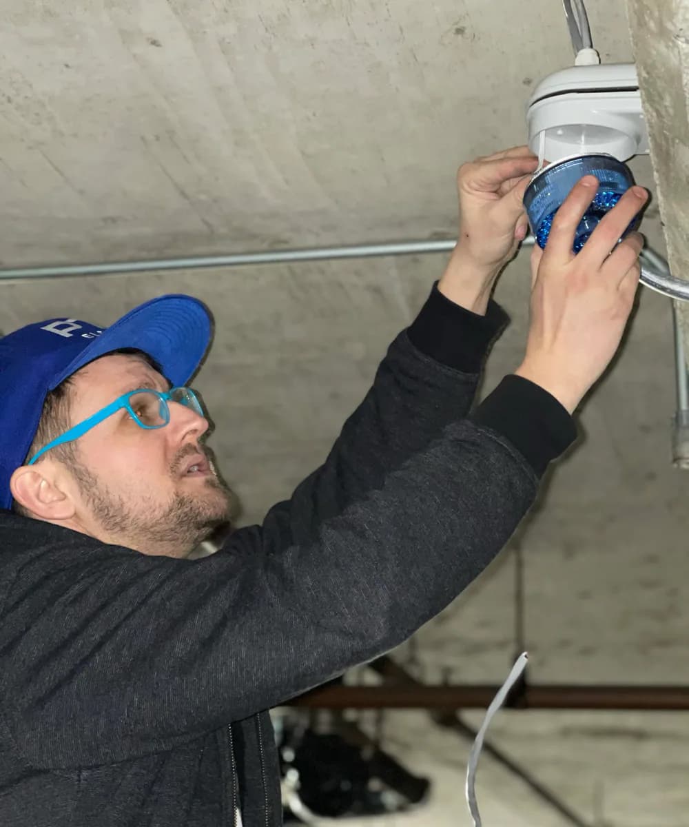 PTX electrician installing a safety device in a parkade