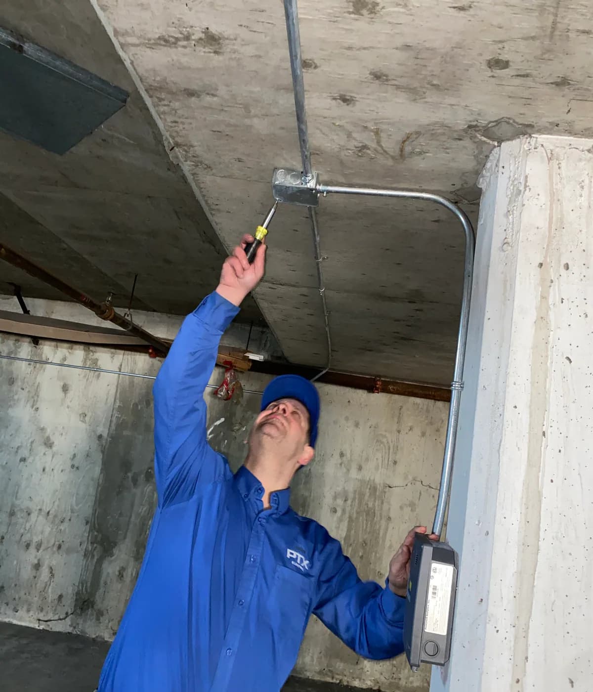 PTX Electric technician completing electrical work in a parkade