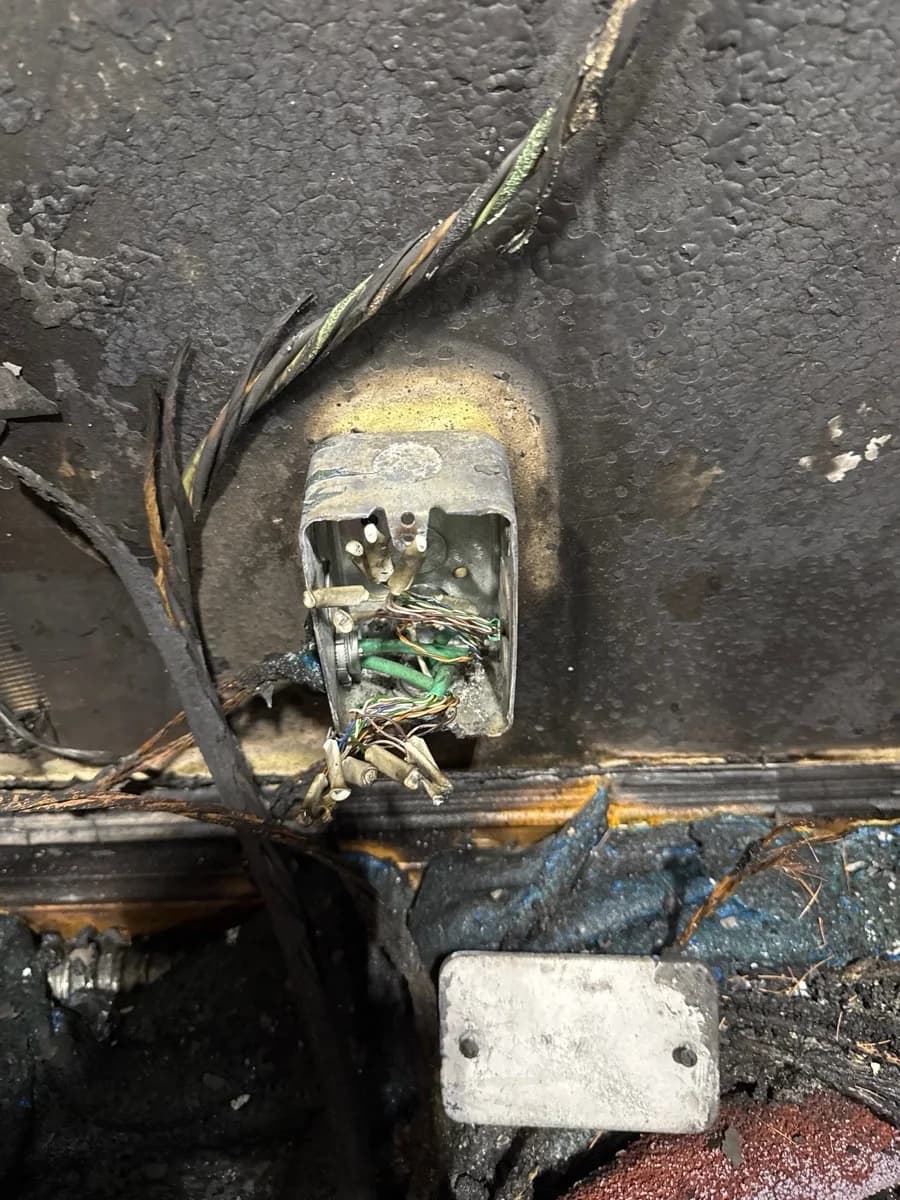 Fire-damaged communications wiring and box before the Delta rebuild