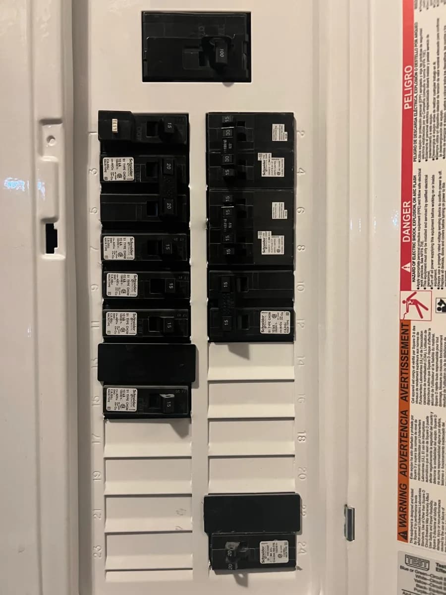 Electrical breaker panel with multiple installed circuit breakers and blank breaker spaces.