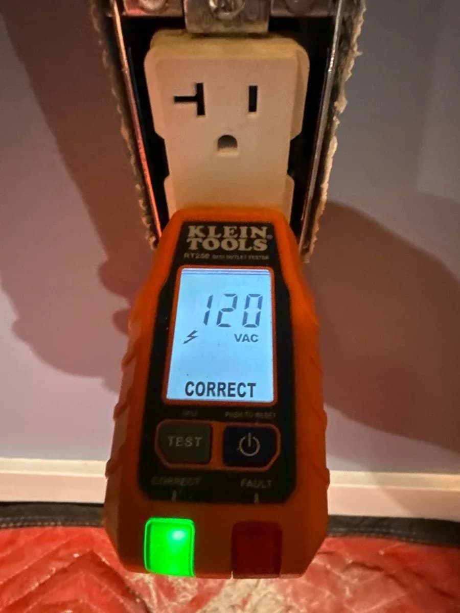 Plug-in outlet tester displaying 120 VAC and “CORRECT” at a wall receptacle.